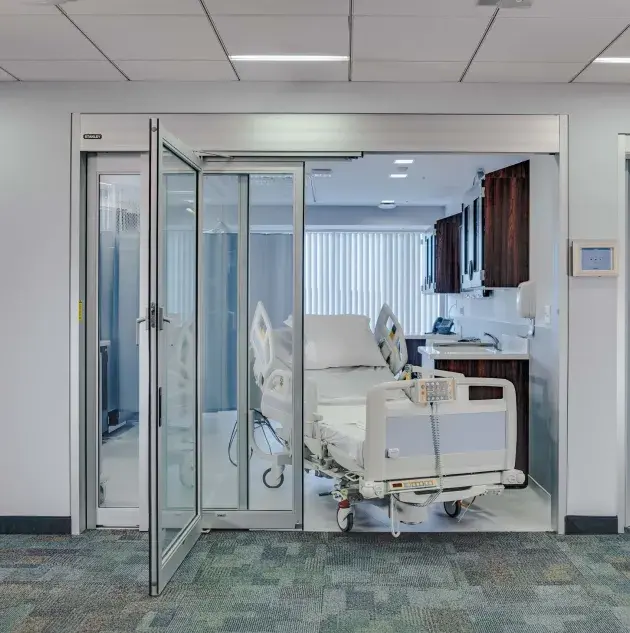 A set of telescoping hospital doors with a bed in the doorway.