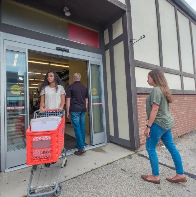 shoppers walking in and out of storefront