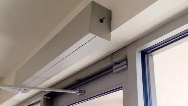 A door with a swinging door opener at the top.