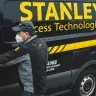 A person closing a van door; on the van it says Stanley Access Technologies.